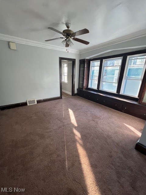 carpeted spare room featuring ornamental molding and ceiling fan