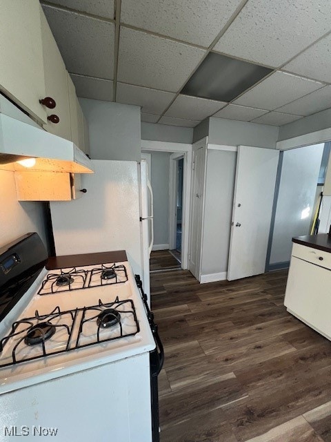 kitchen with a drop ceiling, white cabinetry, white gas range, and dark hardwood / wood-style flooring