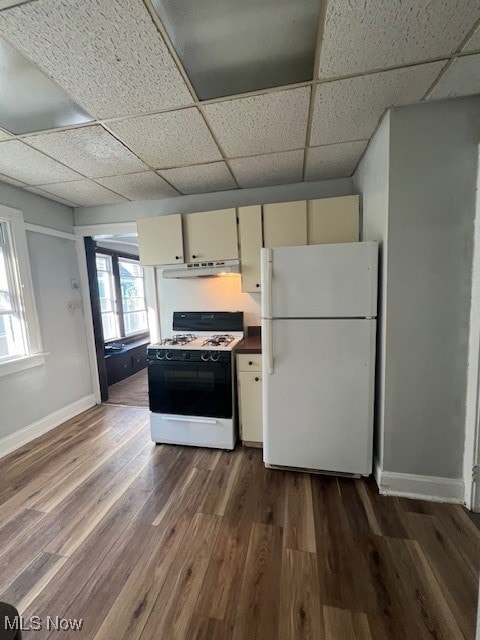 kitchen with cream cabinetry, a paneled ceiling, dark wood-type flooring, and white appliances