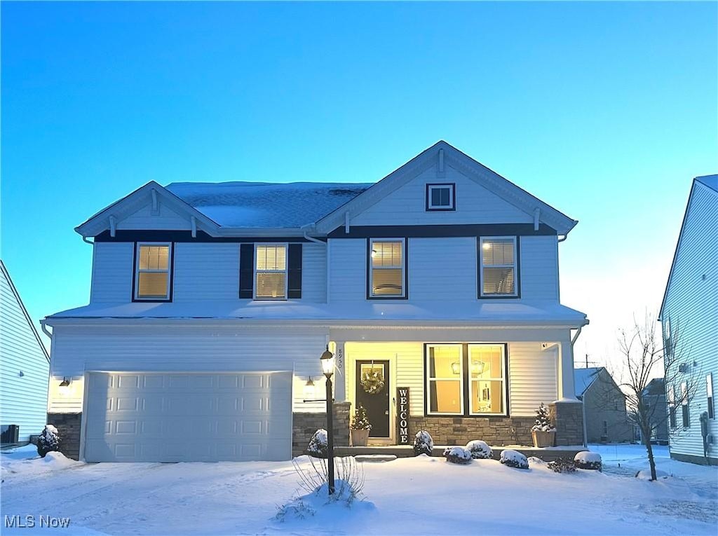 view of front of property with a garage, central AC, and covered porch