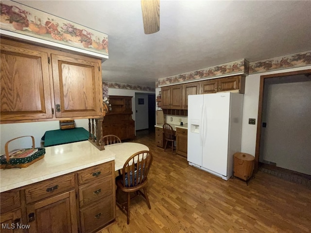 kitchen featuring wood-type flooring, white fridge with ice dispenser, and ceiling fan