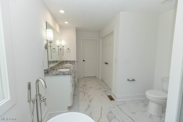 bathroom featuring a bathtub, vanity, and toilet