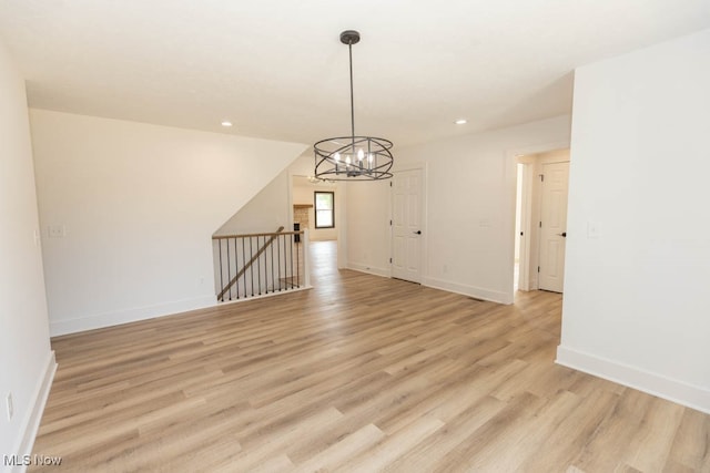 unfurnished dining area featuring light hardwood / wood-style flooring and a chandelier