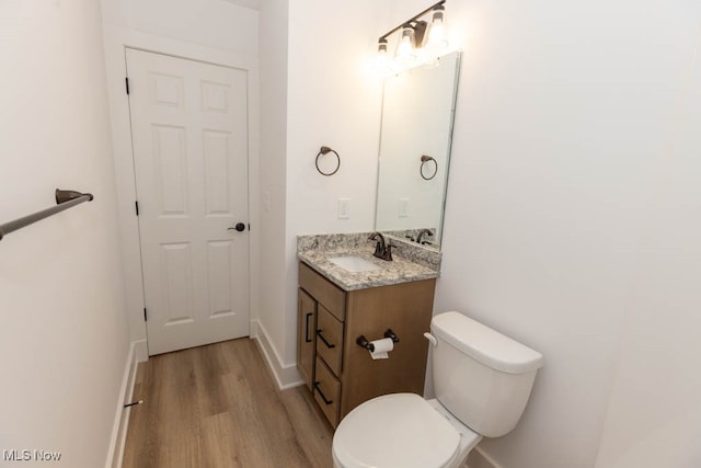 bathroom featuring vanity, toilet, and hardwood / wood-style flooring