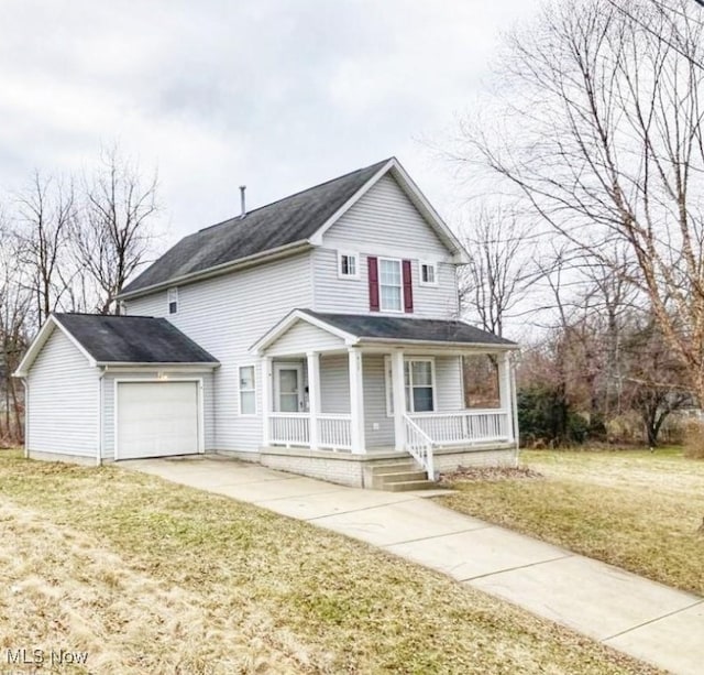 view of front of home with a porch, a front yard, and a garage