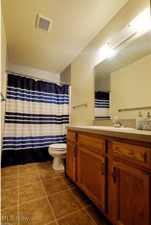 bathroom featuring toilet, vanity, and tile patterned floors