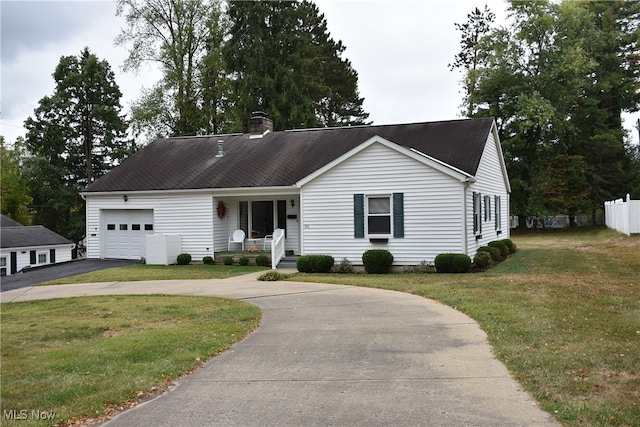 view of front of property featuring a garage, a front lawn, and covered porch