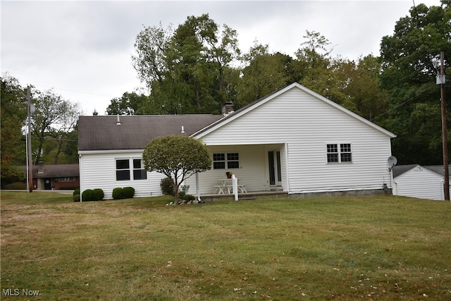 rear view of property featuring a lawn