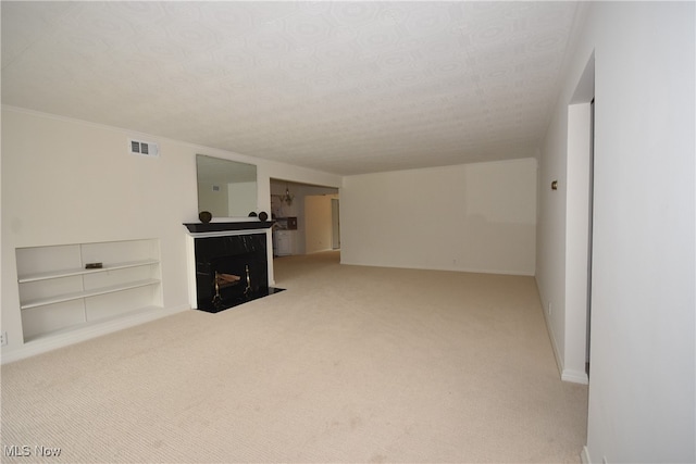 unfurnished living room with light carpet, a textured ceiling, and a high end fireplace