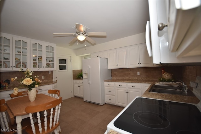 kitchen featuring white refrigerator with ice dispenser, white cabinets, stove, decorative backsplash, and ceiling fan