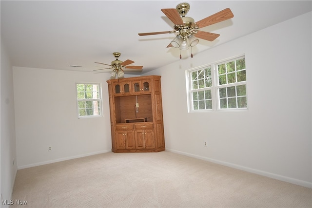 empty room with ceiling fan and light colored carpet