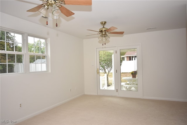 spare room with ceiling fan and light carpet