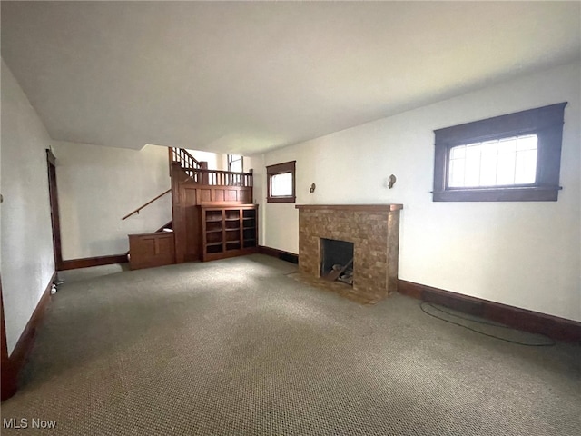 unfurnished living room with carpet floors and a healthy amount of sunlight