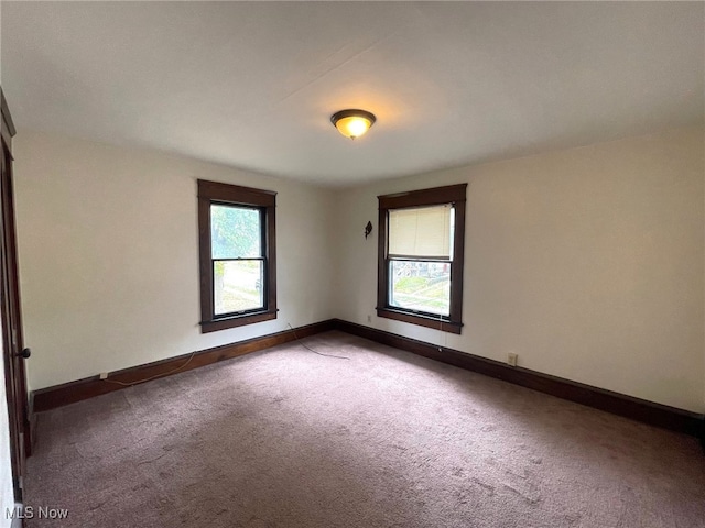 unfurnished room featuring dark colored carpet