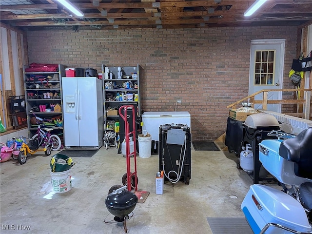 garage featuring white fridge with ice dispenser