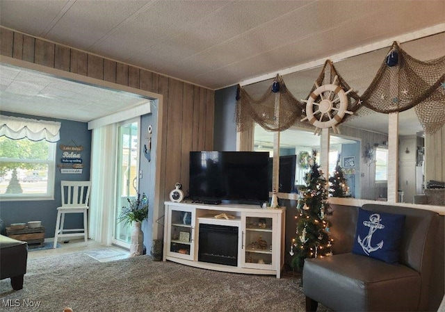 carpeted living room with wooden walls