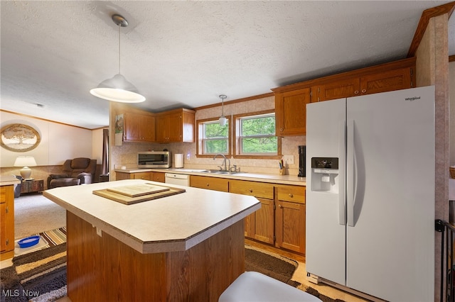 kitchen featuring pendant lighting, ornamental molding, sink, white appliances, and a textured ceiling