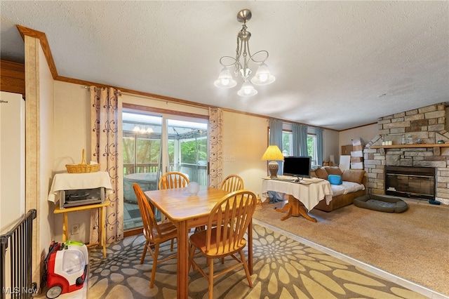 carpeted dining space with a textured ceiling, a notable chandelier, a stone fireplace, radiator, and crown molding