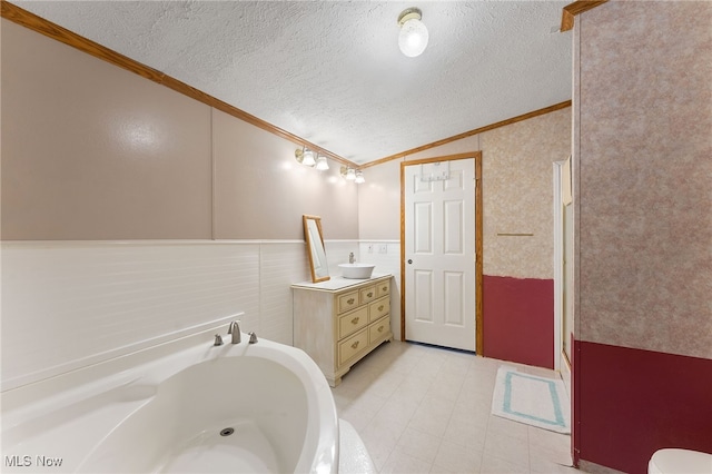 bathroom featuring a textured ceiling, ornamental molding, lofted ceiling, and vanity