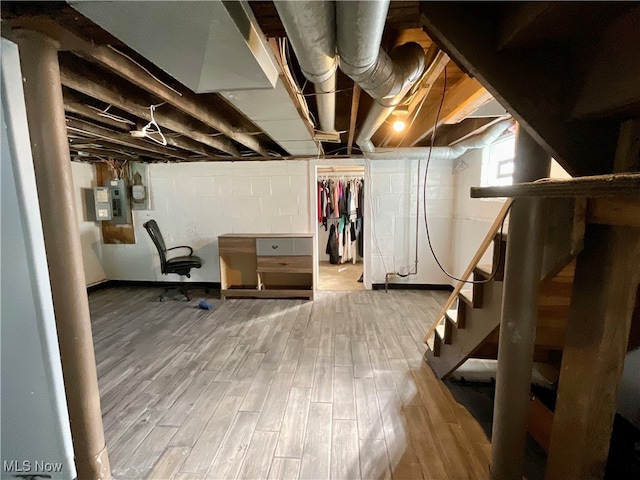 basement with electric panel and wood-type flooring