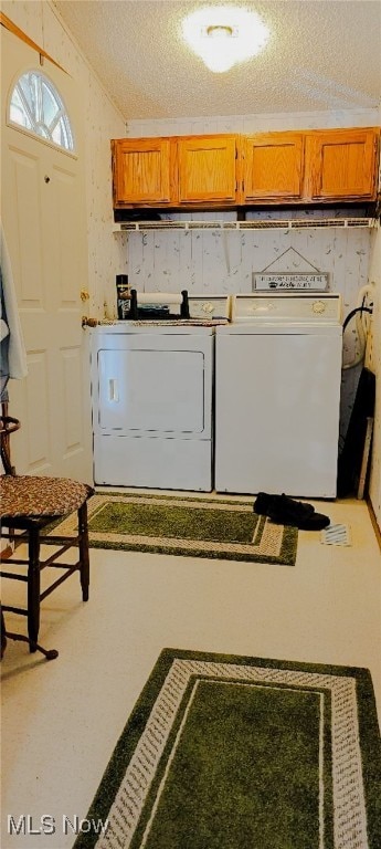 washroom with washing machine and clothes dryer and a textured ceiling