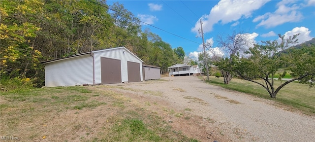 exterior space featuring a garage and an outbuilding