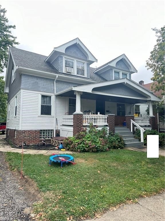 view of front facade with a front lawn and covered porch