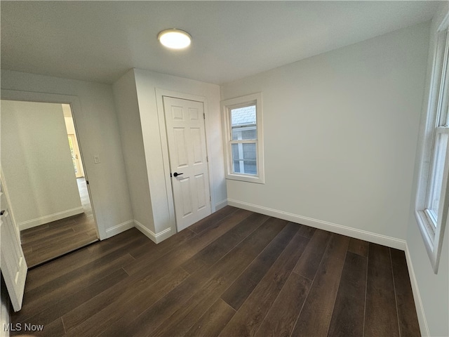 unfurnished bedroom with a closet and dark hardwood / wood-style flooring