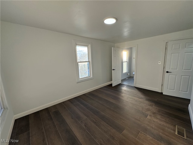 unfurnished room with dark wood-type flooring