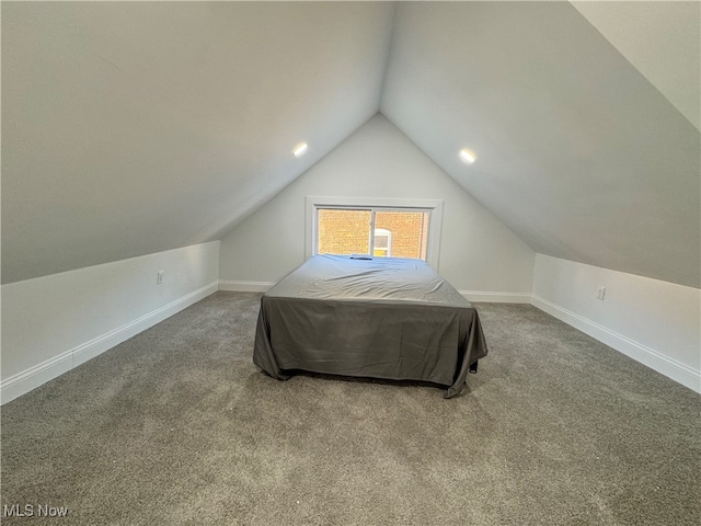 bedroom with carpet floors and vaulted ceiling