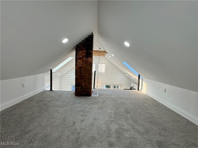 additional living space featuring vaulted ceiling with skylight and carpet flooring