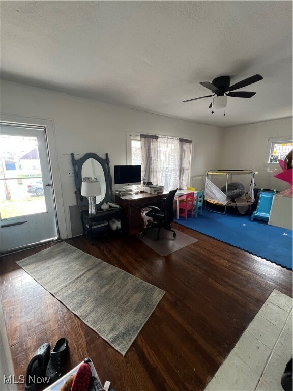 home office with wood-type flooring and ceiling fan