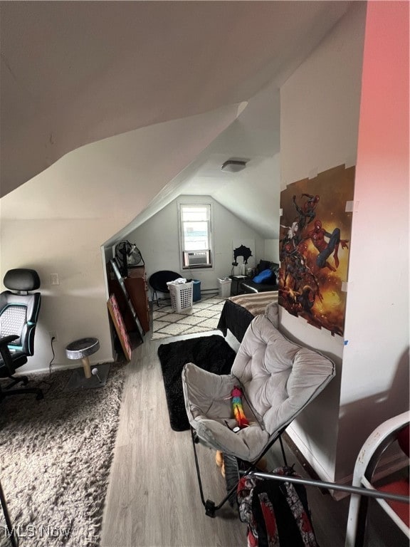 additional living space with wood-type flooring and vaulted ceiling