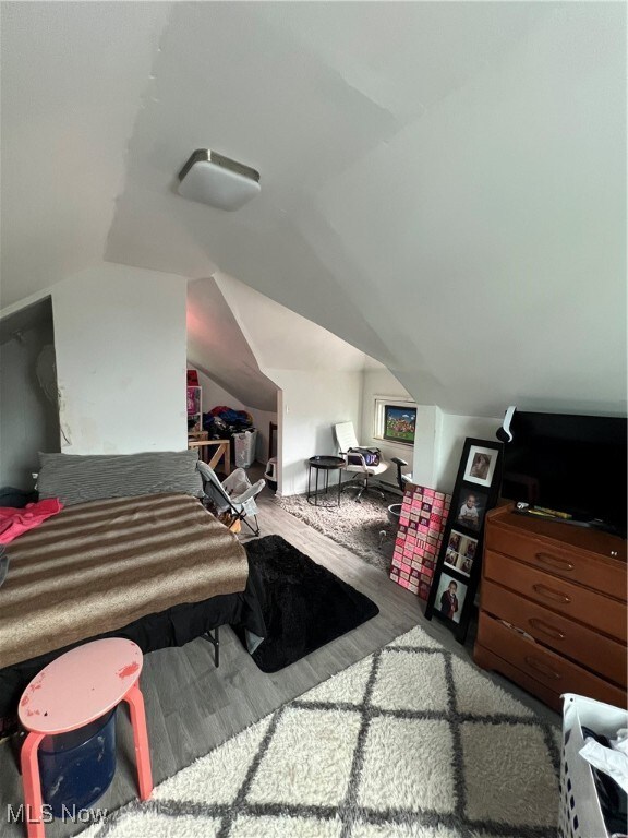 bedroom with hardwood / wood-style floors and vaulted ceiling