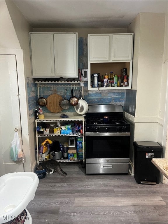 kitchen featuring stainless steel range with gas stovetop, white cabinetry, and light hardwood / wood-style floors