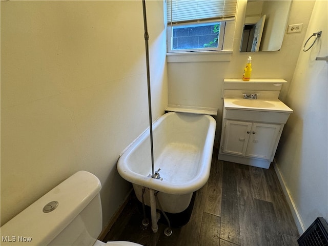 bathroom with vanity, hardwood / wood-style flooring, toilet, and a bath