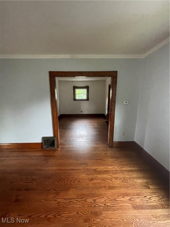 interior space with ornamental molding and dark hardwood / wood-style flooring