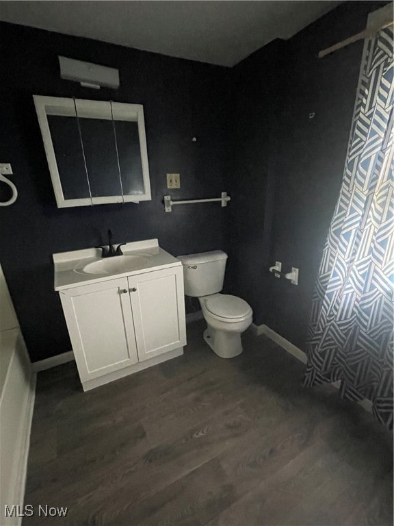 bathroom featuring wood-type flooring, vanity, and toilet