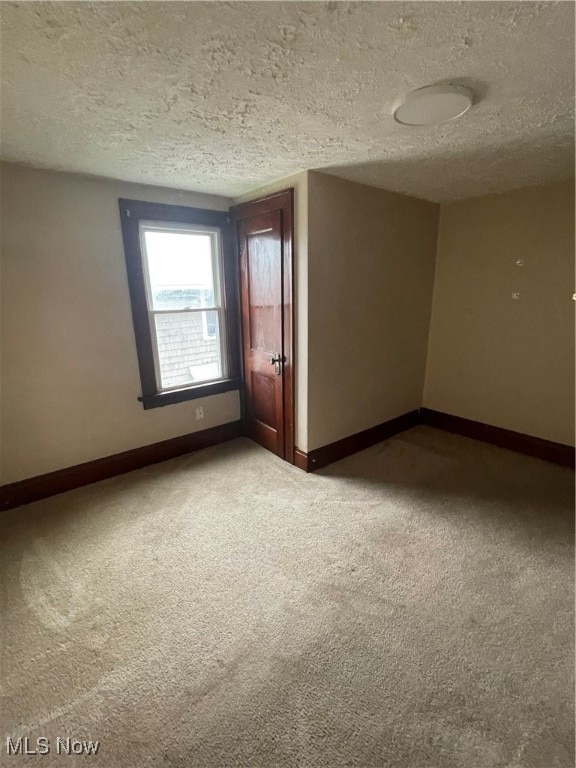 carpeted spare room with a textured ceiling