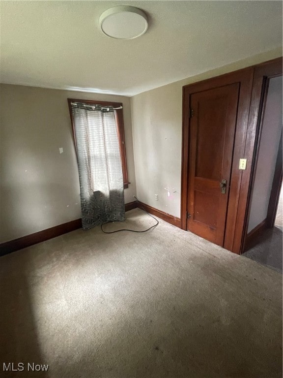 unfurnished bedroom with dark carpet