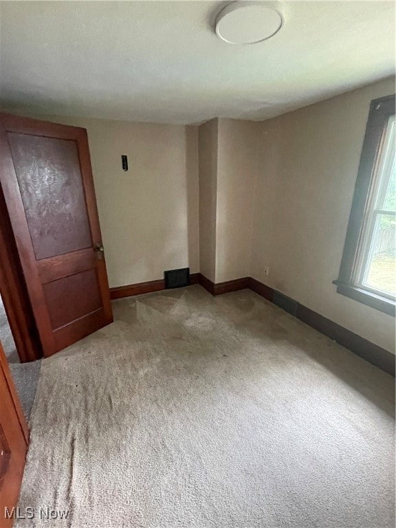 unfurnished room featuring light carpet