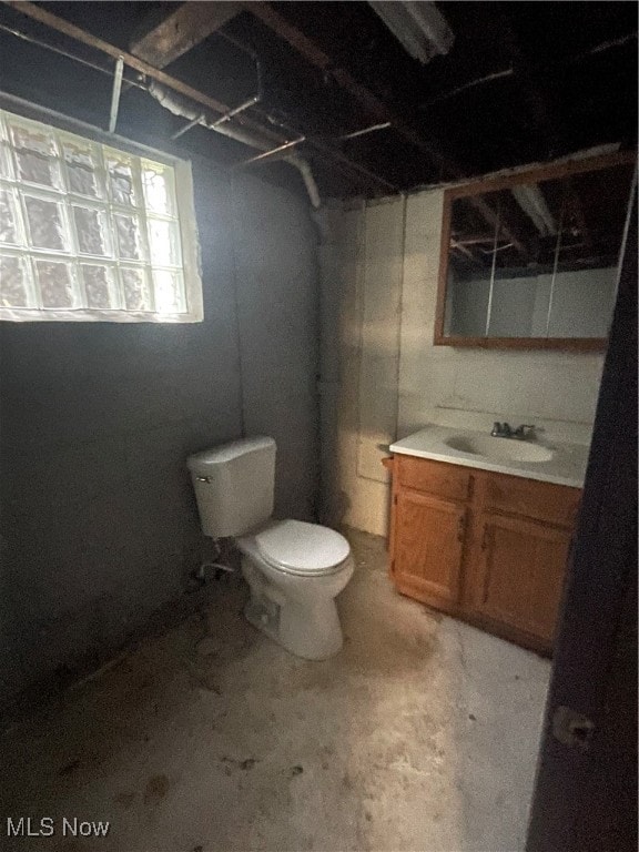 full bathroom with vanity, toilet, concrete floors, and  shower combination