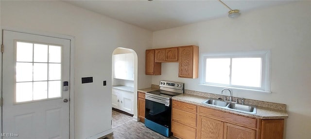 kitchen featuring plenty of natural light, sink, and stainless steel electric range