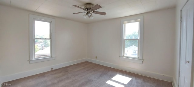 spare room with ceiling fan and light colored carpet