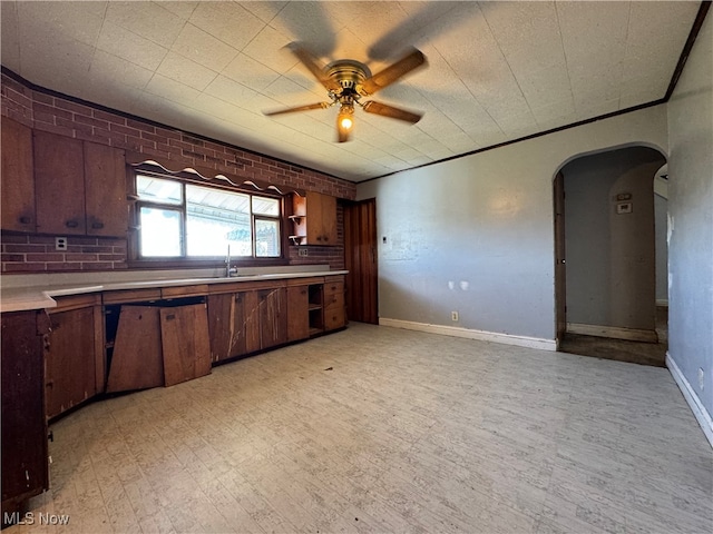 kitchen featuring ceiling fan, built in desk, and sink