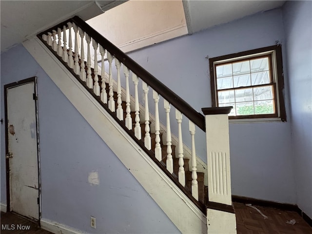 staircase featuring parquet flooring