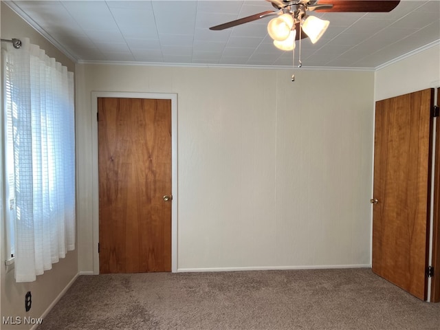 unfurnished bedroom with ornamental molding, carpet, and ceiling fan