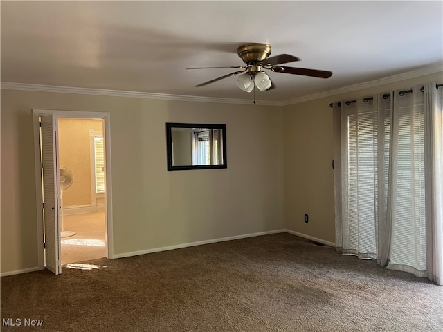 unfurnished room with dark carpet, ceiling fan, plenty of natural light, and ornamental molding