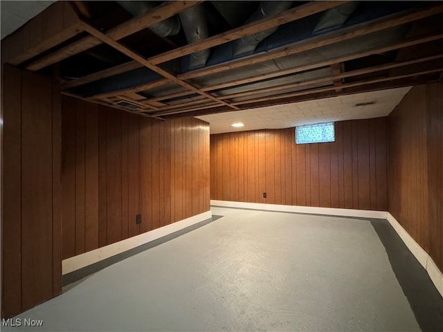 basement featuring wood walls