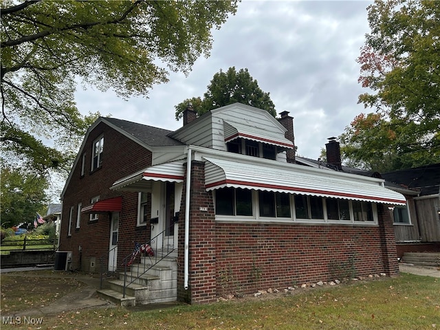 bungalow-style home with central air condition unit